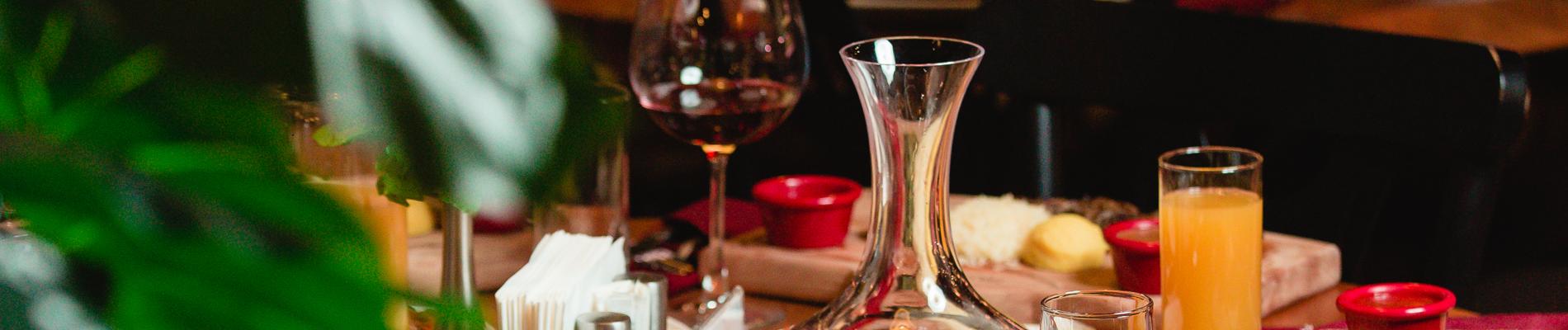 Mesa com taça de vinho, guardanapos e comida