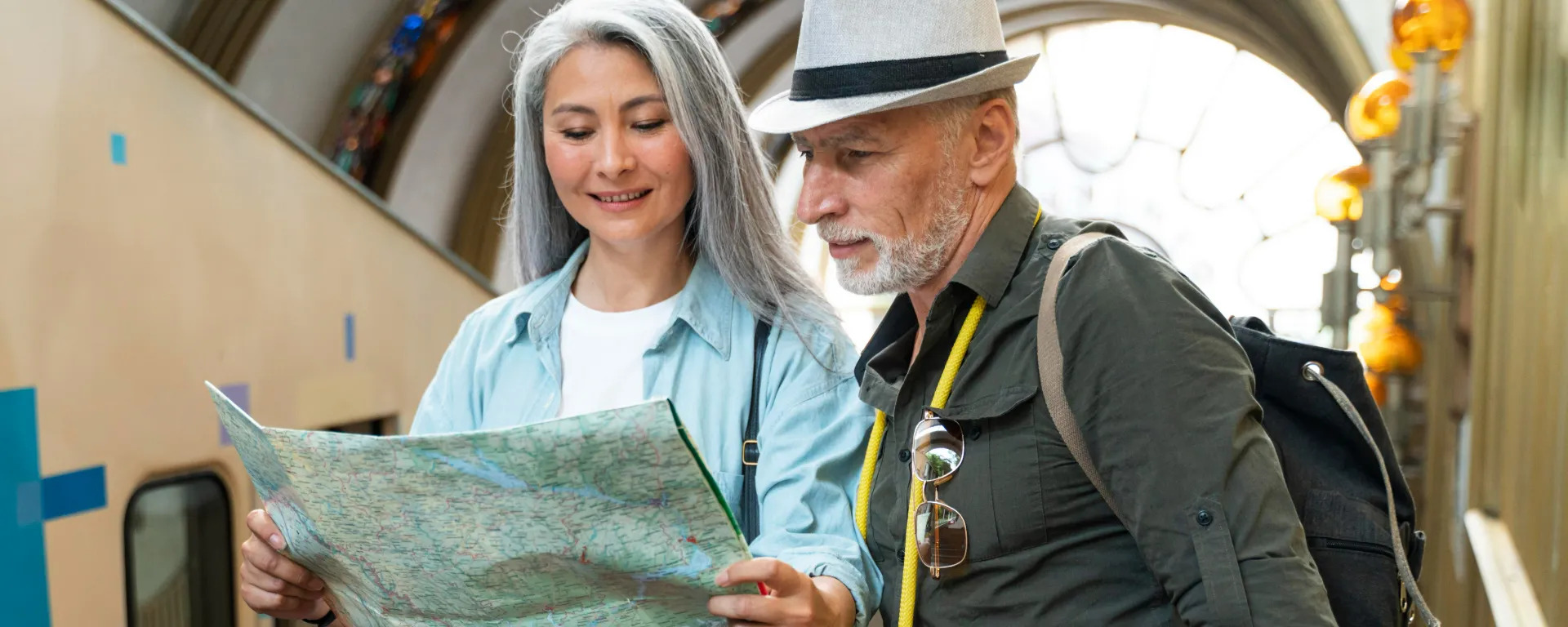 Casal de idosos olhando um mapa durante a viagem.