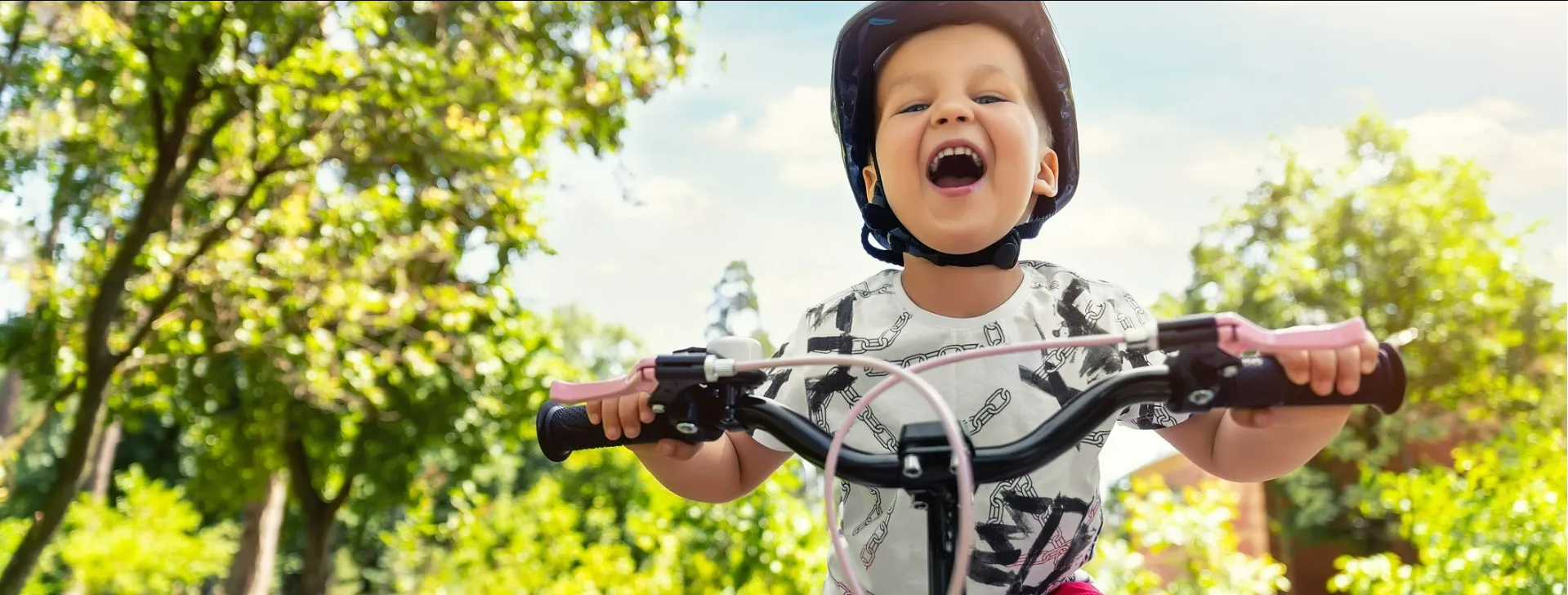 Criança sorrindo em cima de bicicleta